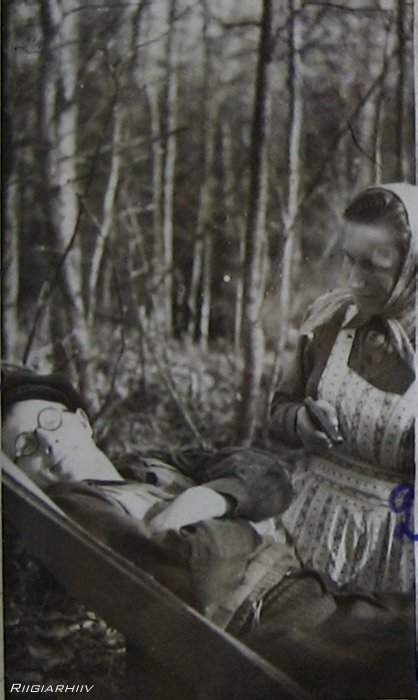 Parmu metsas 1950. Richard Vähi pikutab, naiseriietes ja püstoliga Raimond Pild.